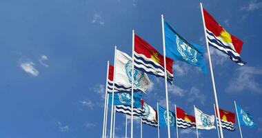 Kiribati et uni nations, ONU drapeaux agitant ensemble dans le ciel, sans couture boucle dans vent, espace sur la gauche côté pour conception ou information, 3d le rendu video