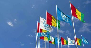 Guinée et uni nations, ONU drapeaux agitant ensemble dans le ciel, sans couture boucle dans vent, espace sur la gauche côté pour conception ou information, 3d le rendu video