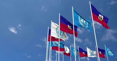 Haití y unido naciones, Naciones Unidas banderas ondulación juntos en el cielo, sin costura lazo en viento, espacio en izquierda lado para diseño o información, 3d representación video