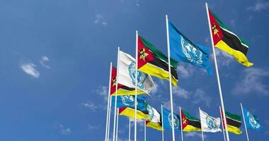 mozambique et uni nations, ONU drapeaux agitant ensemble dans le ciel, sans couture boucle dans vent, espace sur la gauche côté pour conception ou information, 3d le rendu video