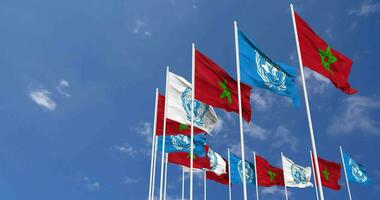 Maroc et uni nations, ONU drapeaux agitant ensemble dans le ciel, sans couture boucle dans vent, espace sur la gauche côté pour conception ou information, 3d le rendu video