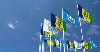 Saint Vincent et le grenadines et uni nations, ONU drapeaux agitant ensemble dans le ciel, sans couture boucle dans vent, espace sur la gauche côté pour conception ou information, 3d le rendu video