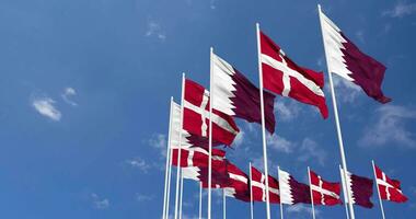 Dinamarca y Katar banderas ondulación juntos en el cielo, sin costura lazo en viento, espacio en izquierda lado para diseño o información, 3d representación video