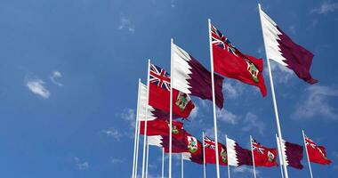 Bermudes et Qatar drapeaux agitant ensemble dans le ciel, sans couture boucle dans vent, espace sur la gauche côté pour conception ou information, 3d le rendu video