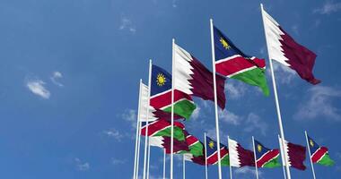 Namibie et Qatar drapeaux agitant ensemble dans le ciel, sans couture boucle dans vent, espace sur la gauche côté pour conception ou information, 3d le rendu video