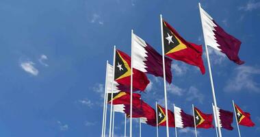 East Timor and Qatar Flags Waving Together in the Sky, Seamless Loop in Wind, Space on Left Side for Design or Information, 3D Rendering video