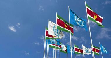 Suriname and United Nations, UN Flags Waving Together in the Sky, Seamless Loop in Wind, Space on Left Side for Design or Information, 3D Rendering video