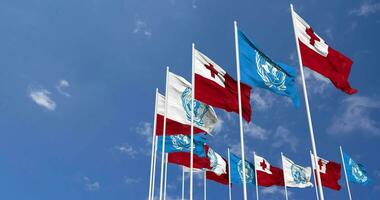 tonga y unido naciones, Naciones Unidas banderas ondulación juntos en el cielo, sin costura lazo en viento, espacio en izquierda lado para diseño o información, 3d representación video