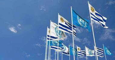 uruguay och förenad nationer, fn flaggor vinka tillsammans i de himmel, sömlös slinga i vind, Plats på vänster sida för design eller information, 3d tolkning video