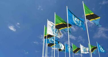 Tanzanie et uni nations, ONU drapeaux agitant ensemble dans le ciel, sans couture boucle dans vent, espace sur la gauche côté pour conception ou information, 3d le rendu video