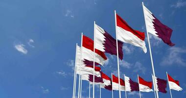 Indonésie et Qatar drapeaux agitant ensemble dans le ciel, sans couture boucle dans vent, espace sur la gauche côté pour conception ou information, 3d le rendu video