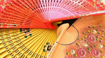 Set of traditional hand fans decorated with flowers and made in wood gyrating video