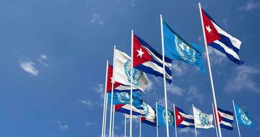 Cuba et uni nations, ONU drapeaux agitant ensemble dans le ciel, sans couture boucle dans vent, espace sur la gauche côté pour conception ou information, 3d le rendu video