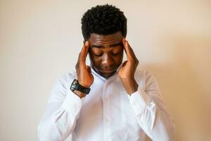 Portrait of young businessman who is tired and having headache. photo