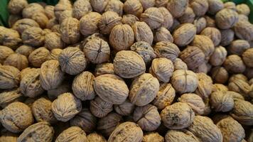 walnuts are piled up in a green container photo