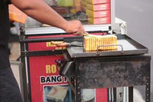 Selective focus. Making a Malaysian Dessert,Martabak Manis. The process of making sweet martabak terang bulan. photo