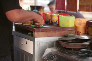 Selective focus. Making a Malaysian Dessert,Martabak Manis. The process of making sweet martabak terang bulan. photo