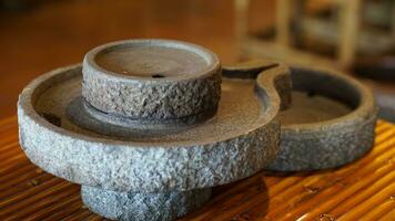 a stone bowl sitting tea on top of a bamboo table photo