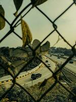 a view of a highway through a chain link fence photo