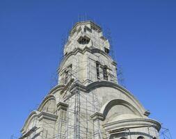 Construction of an Orthodox chapel. Scaffolds along the walls of the building photo