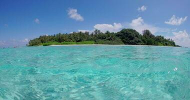 voor de helft onderwater- transparant oceaan en visie met tropisch eiland in Maldiven video