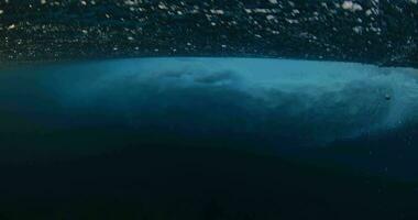 unter Wasser Aussicht von das Ozean Welle brechen mit viele von Schaum und Luftblasen video