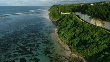 Ocean coastline with road on cliff in Bali. Aerial view video