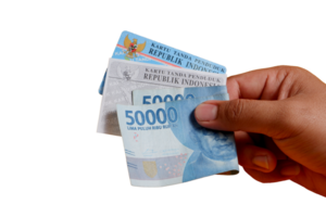 A man's hand is holding a photocopy of his KTP and a 50,000 rupiah note. concept illustration of buying or bribing election votes png