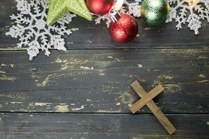 Christmas Holiday Ornaments and Christian Cross on a Dark Wood Background. photo