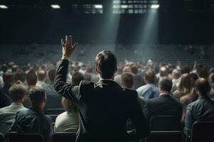 AI generated Rear view of businessman pointing with finger at crowd in concert hall, businessman standing hand rise asking question in midddel of seminar convention hall, AI Generated photo