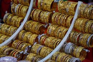 Indian rings and bracelets in silver and gold and jewelry on the counter in store. photo