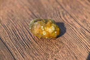 Stone of gallbladder. The result of gallstones. A calculus of dissimilar composition on a wooden background. photo