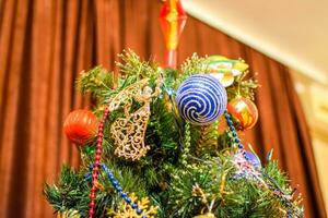 decoraciones nuevo año árbol. oropel y juguetes, pelotas y otro decoraciones en el Navidad Navidad árbol en pie en el abierto aire. foto