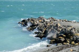 Stones on the sea shore. Waves are beating against stones photo