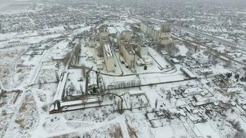 Grain terminal in the winter season. Snow-covered grain elevator in rural areas. A building for drying and storing grain. photo