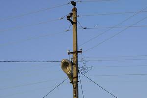 power line post with a street lighting lamp. blue sky. photo