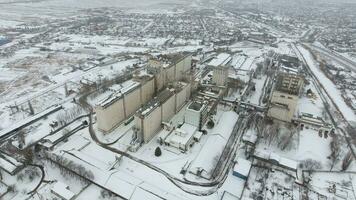 Grain terminal in the winter season. Snow-covered grain elevator in rural areas. A building for drying and storing grain. photo