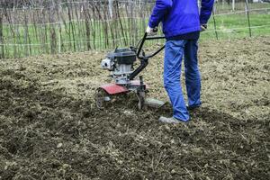 plantando patatas debajo el con operador a pie tractor foto