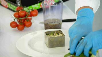 Hands of chef adding salad to a fish tartar video