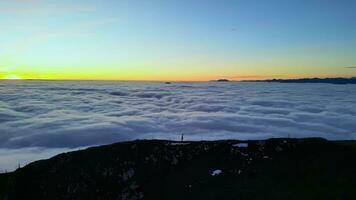 montañas picos y escaladores terminado el nubes a el puesta de sol video