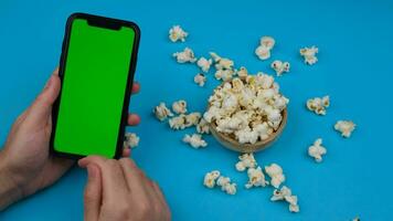 grön skärm telefon använder sig av och popcorn. hög kvalitet 4k antal fot video