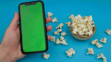 grön skärm telefon och popcorn. hög kvalitet 4k antal fot video