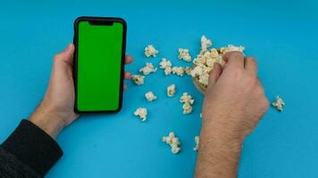 eating popcorn with smart phone. High quality 4k footage video