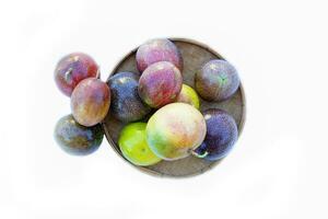 isolated Passion fruit in a bamboo basket on white background. The passion fruit has an oval shape, a thick, oily rind. There are many seeds inside the fruit. It is a healthy fruit with high fiber. photo