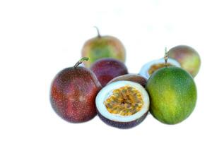 isolated passion fruit on white background. The passion fruit has an oval shape, a thick, oily rind. There are many seeds inside the fruit. It is a healthy fruit with high fiber content. photo