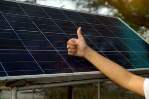 Thumbs up for solar panels with standard usage. Concept for renewable energy, energy and environment conservation, global warming. Soft and selective focus. photo