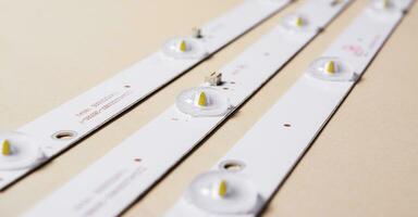 LED strips with lamps for an LCD TV or monitor on a light background. Repair of TVs, monitors. Side view. photo