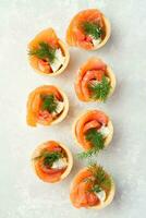 Snack with red fish on a light table. Festive snack. Menu for the festive table. View from above. Copy space. photo