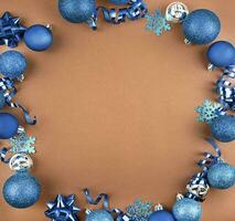 Christmas frame from Christmas blue balls, serpentine on a brown background. Christmas background. Flat lay, top view. Copy space. photo