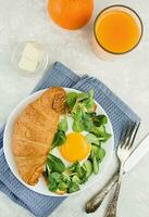 europeo desayuno con Fresco cruasanes, revuelto huevos, hierbas y naranja jugo. desayuno en un ligero mesa, parte superior vista. comida antecedentes. foto